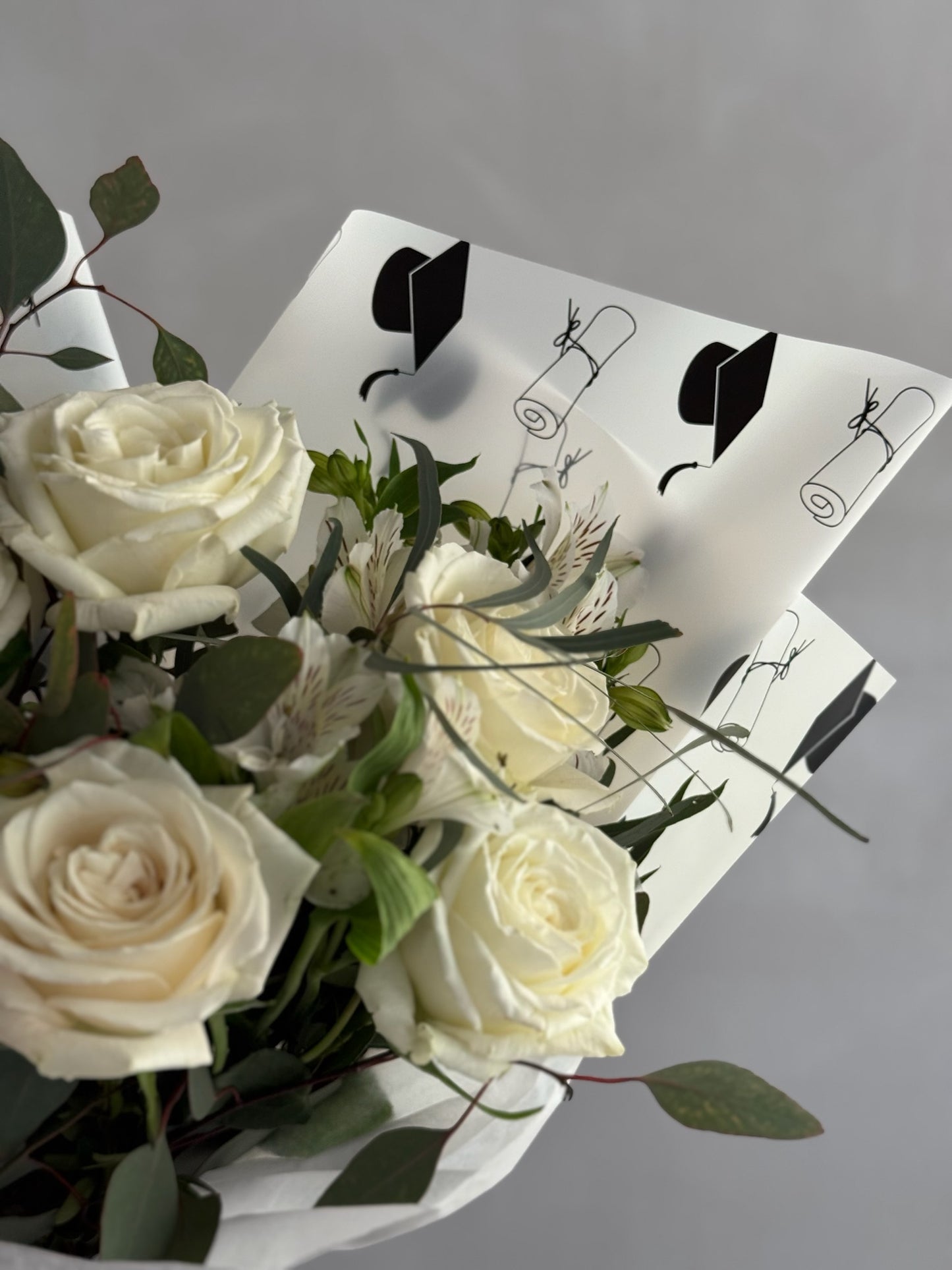 Graduation bouquet with white flowers on grey background
