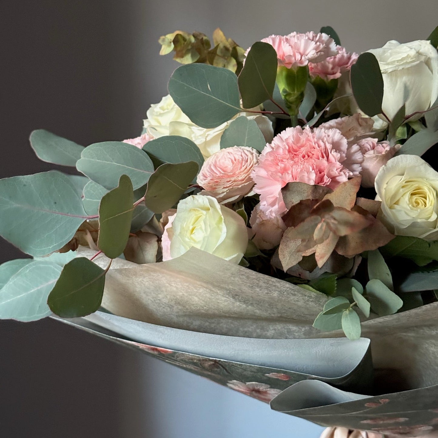 Bouquet of flowers with pink and white roses on a gray background