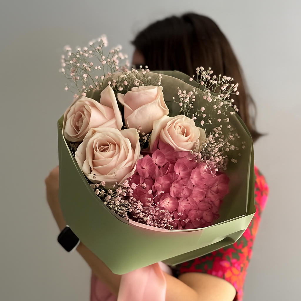 Person holding a bouquet of flowers with a plain background