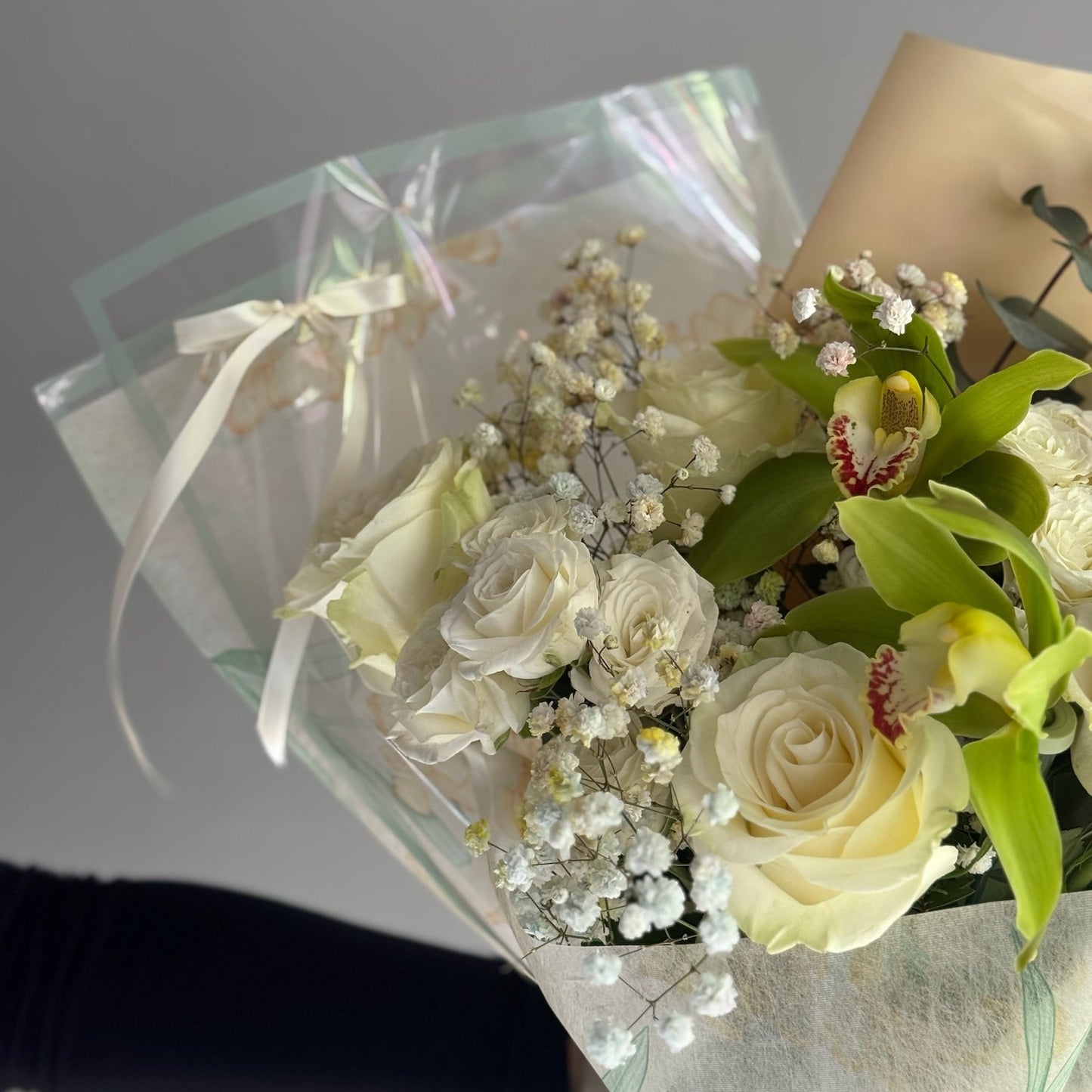 White roses and green orchids in bouquet