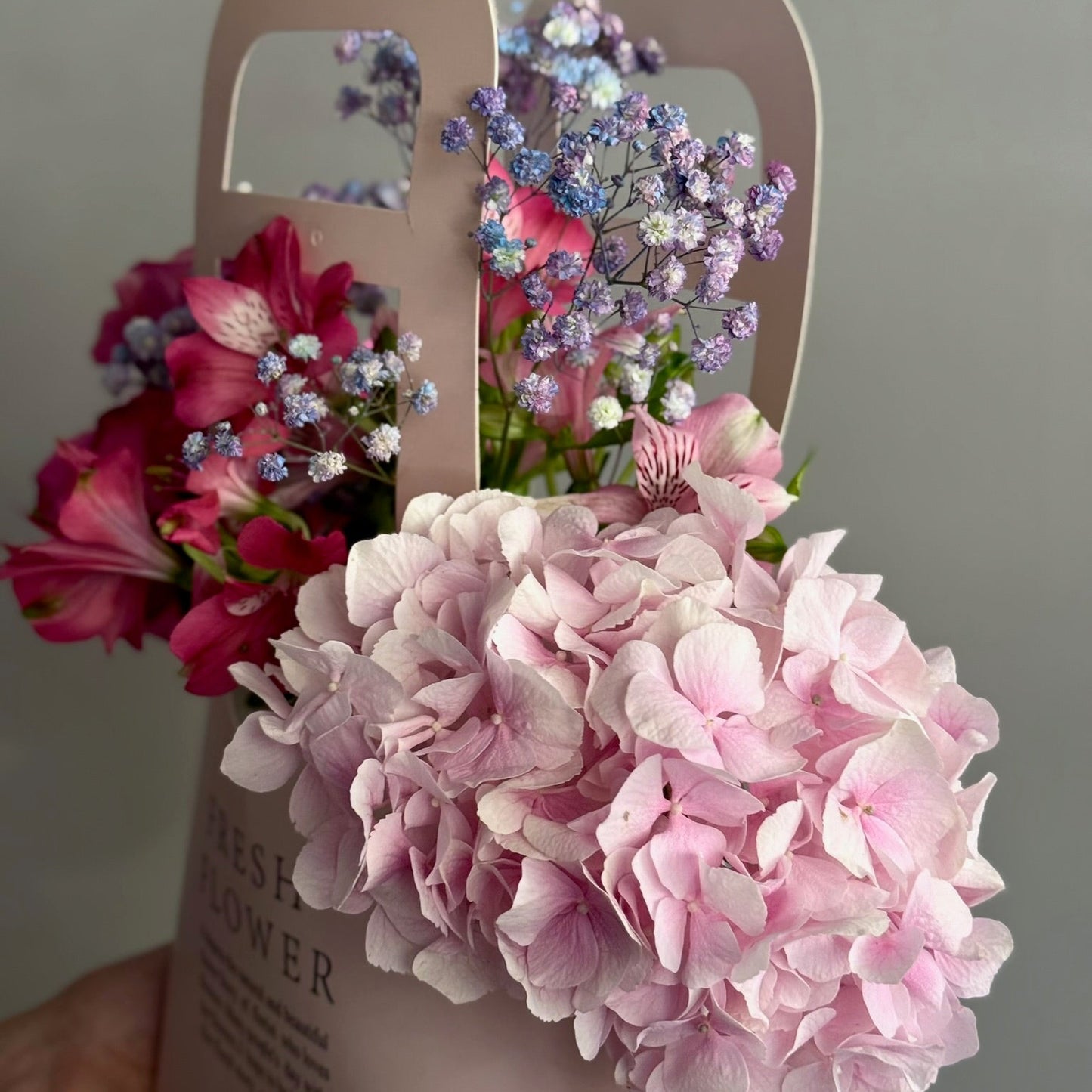 Aranjament floral în pungă roz cu trandafiri de grădină și alstroemeria, Roses & More