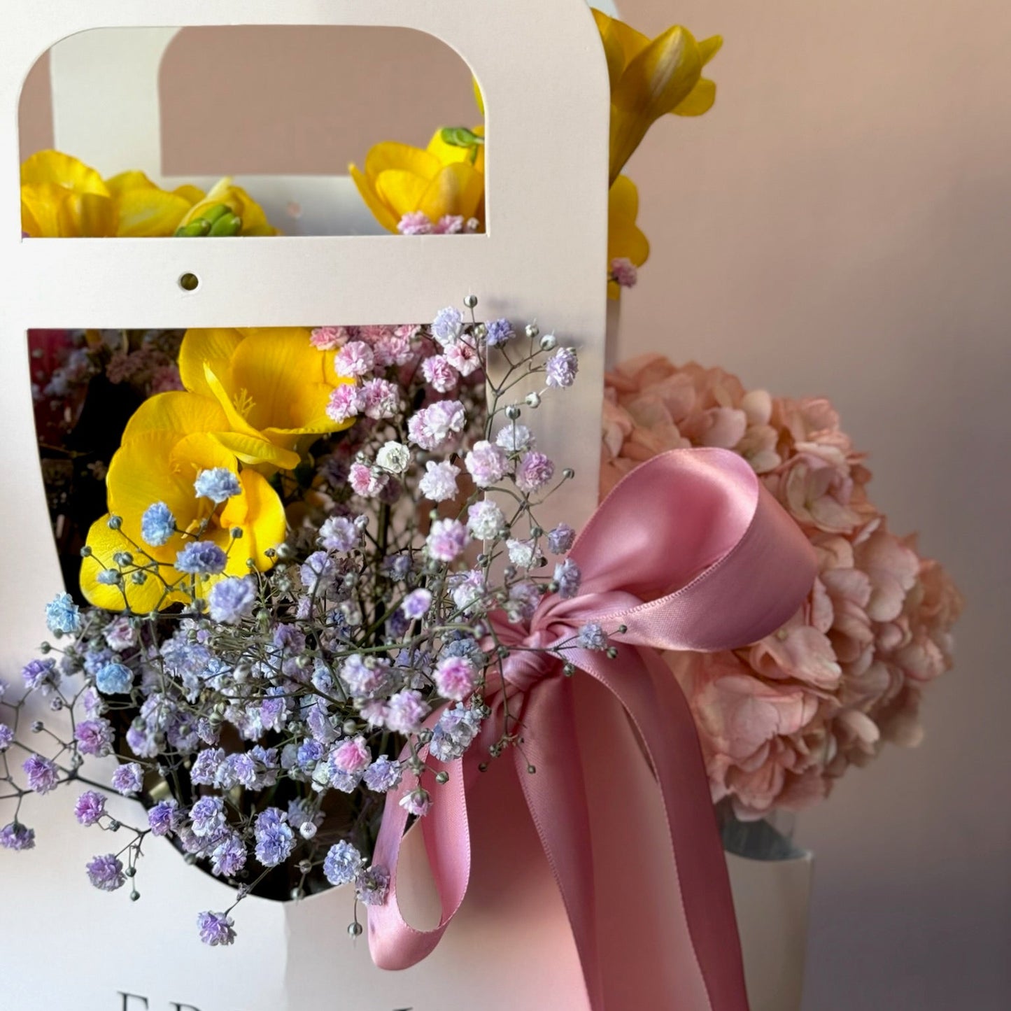 Aranjament floral vibrant în pungă roz – combinație de Miyabi și frezii, Roses & More