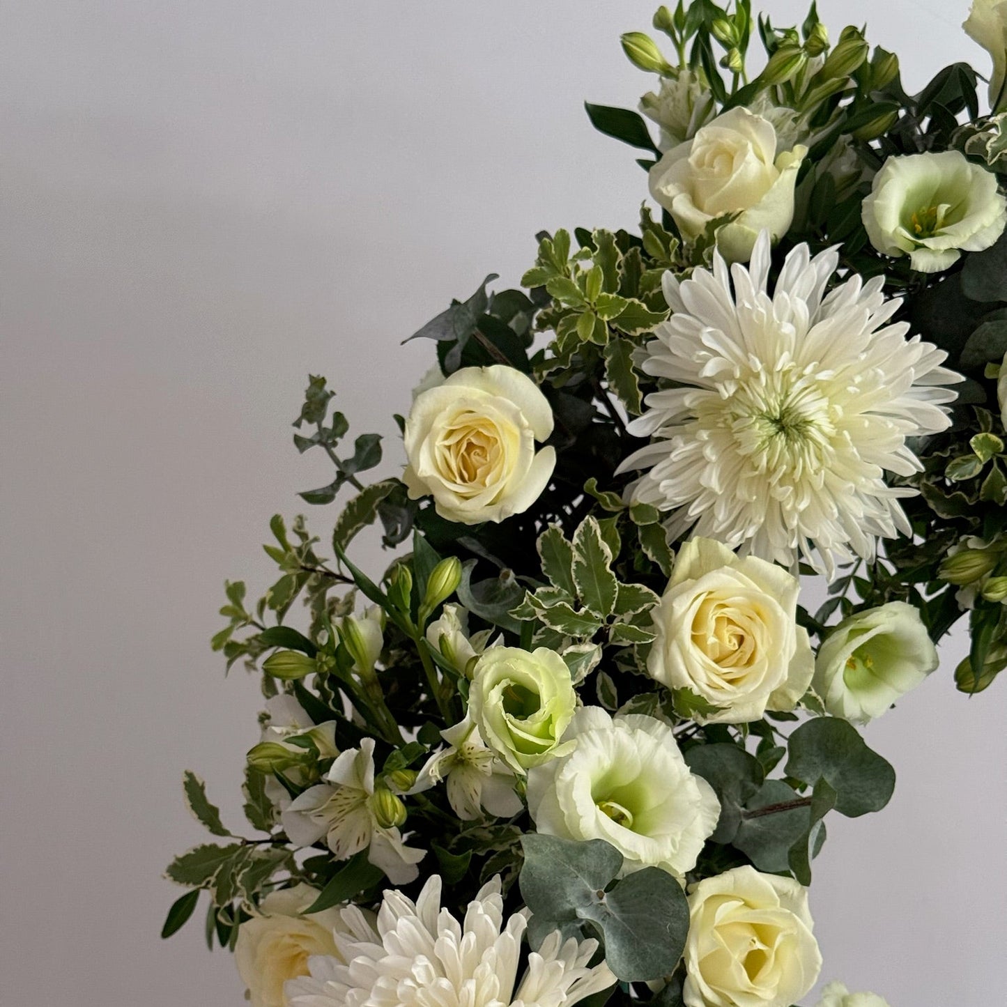 Bouquet of white and light green flowers with green leaves on a gray background
