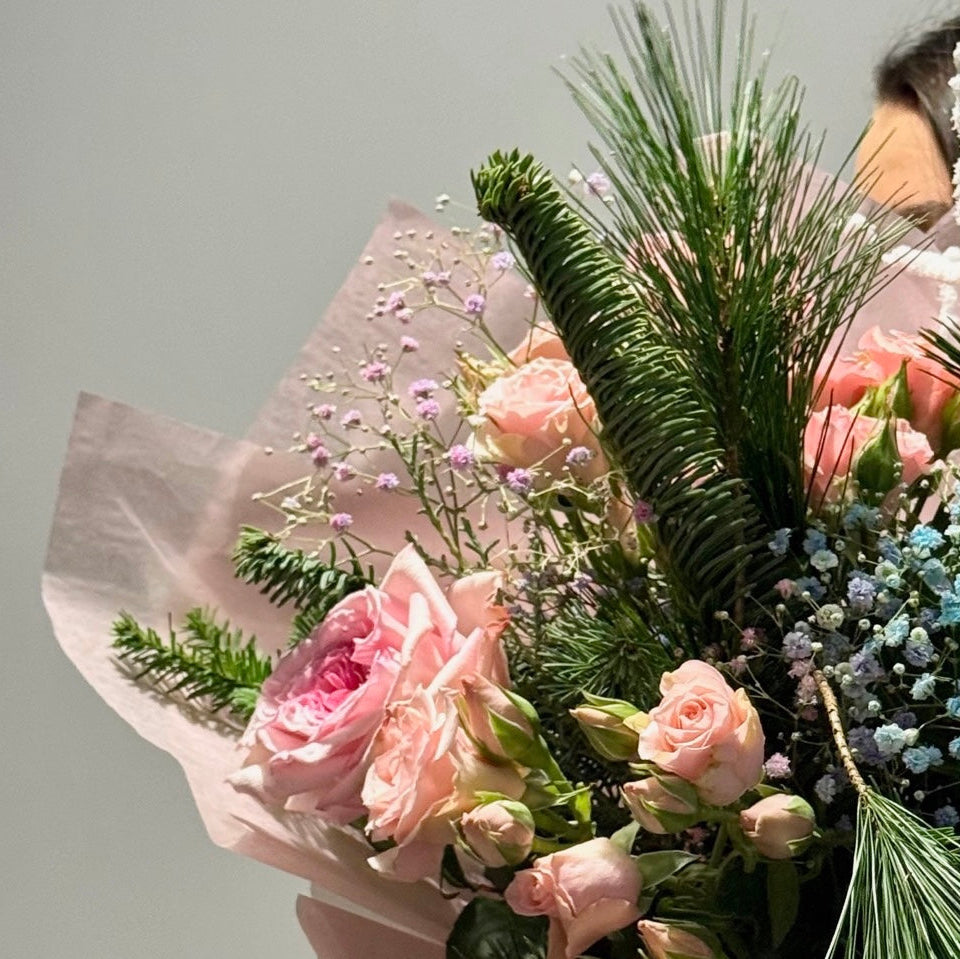 Bouquet of pink roses and greenery on a light gray background