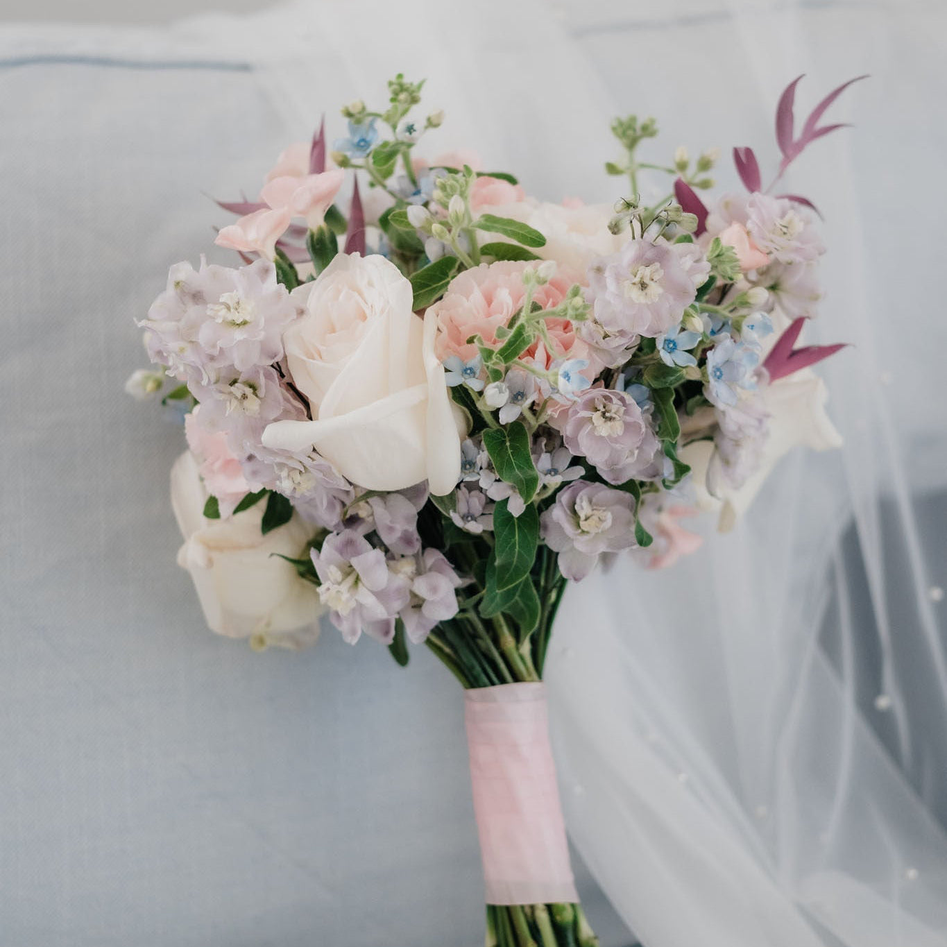 Bouquet of flowers with white and pink roses on a light gray background