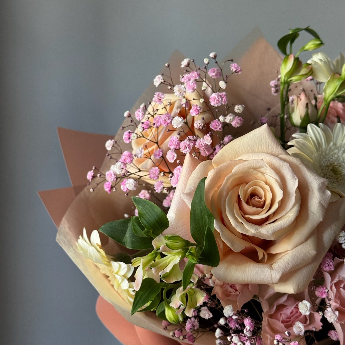 Bouquet of flowers with pink and white roses on a gray background