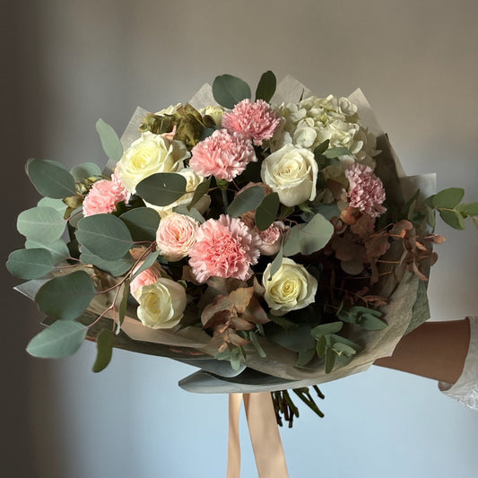 Bouquet of flowers held by a person with a blurred background