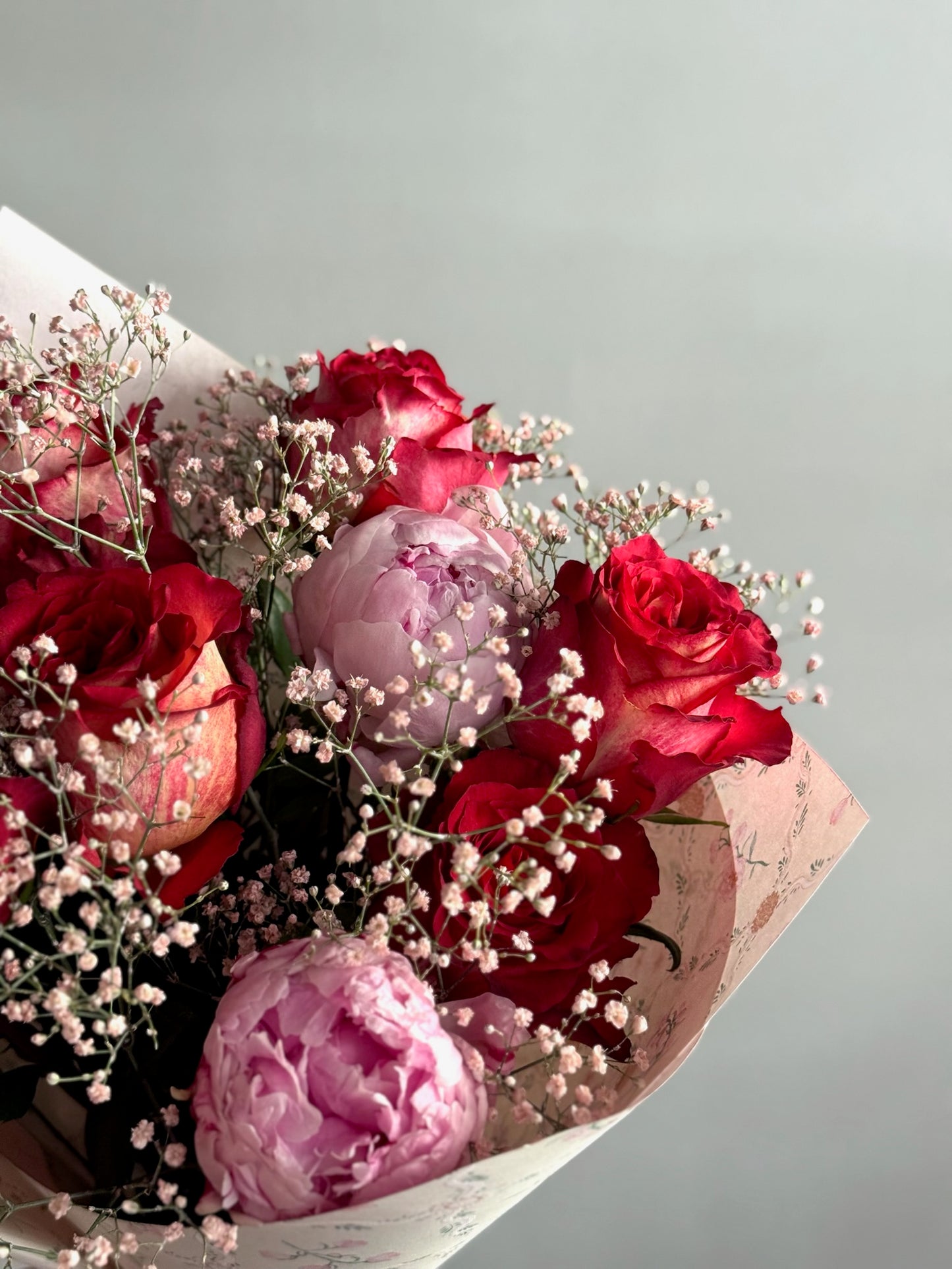 Buchet romantic cu trandafiri roșii și bujori roz
