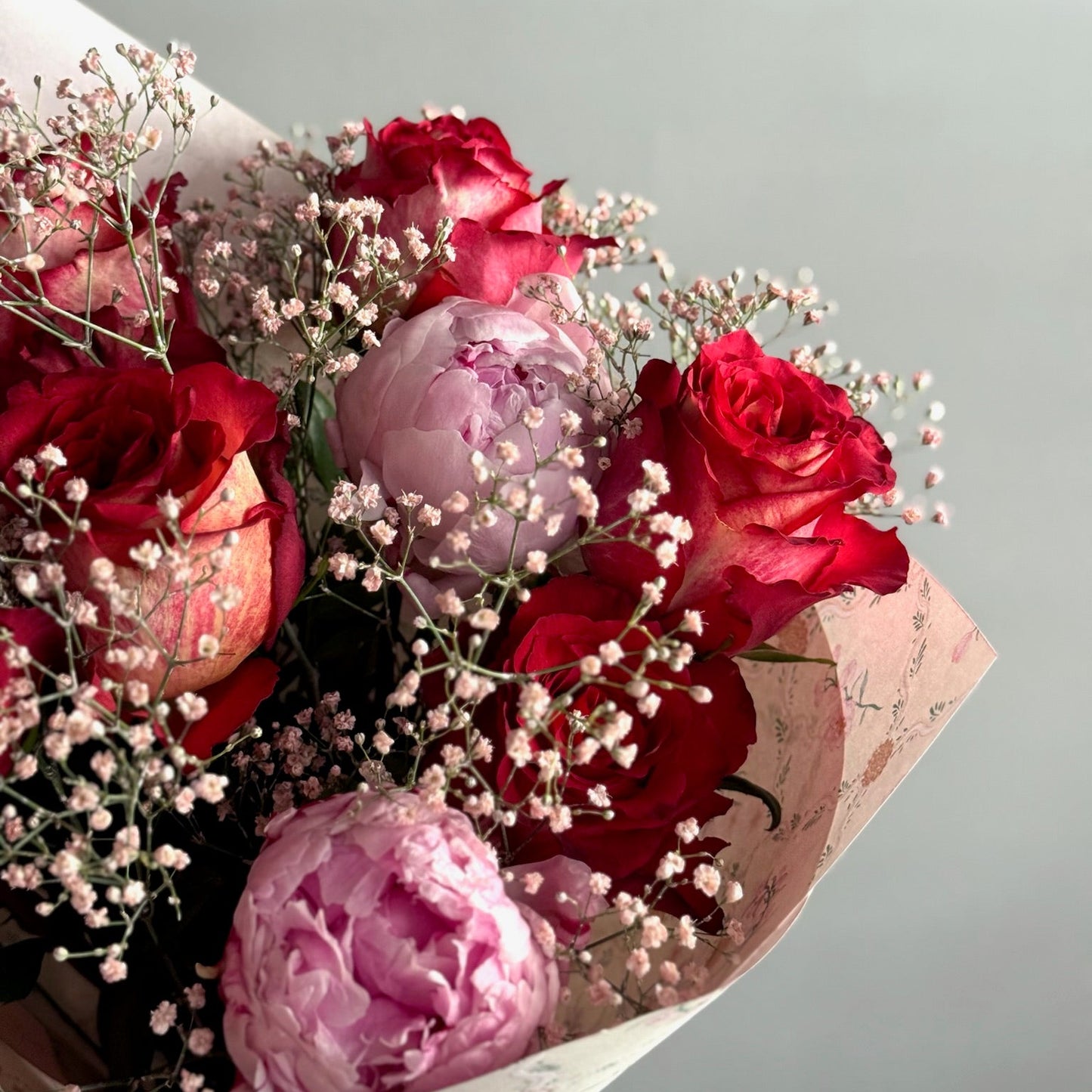 Buchet romantic cu trandafiri roșii și bujori roz