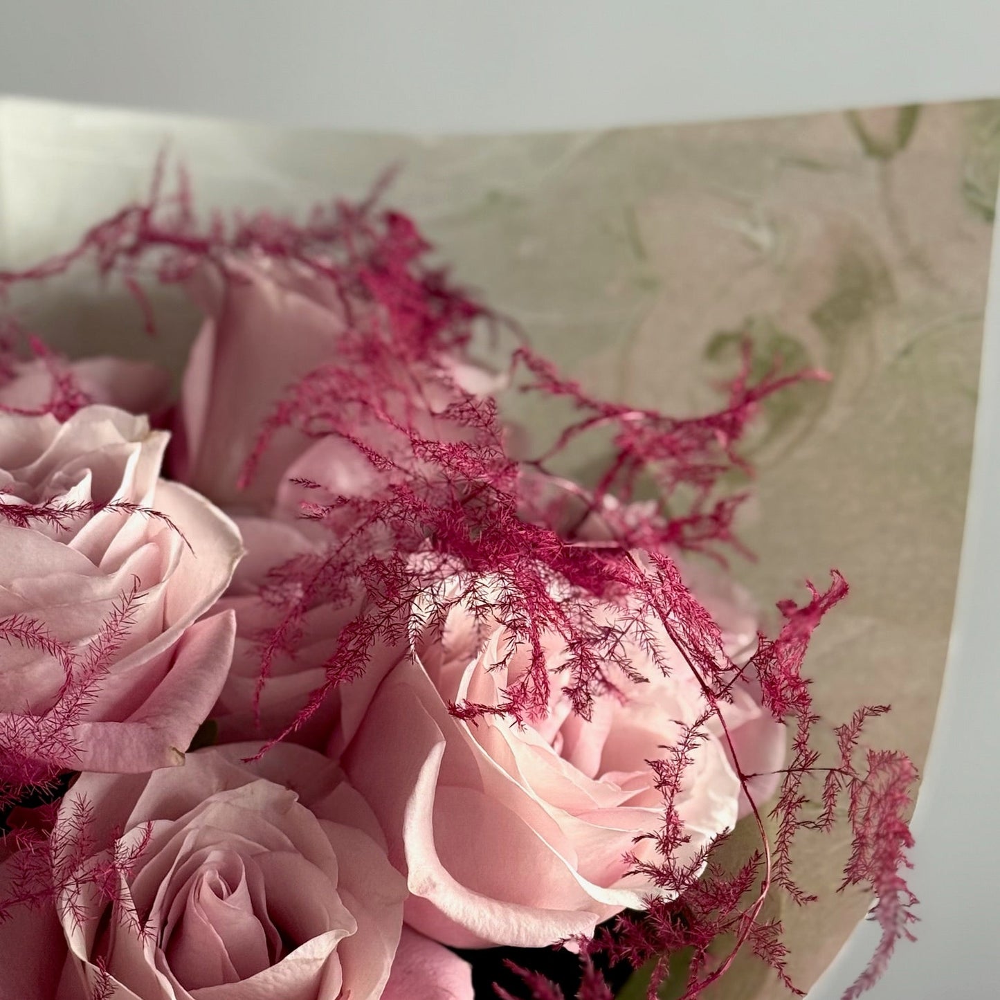 Bouquet of pink flowers with green leaves on a white background