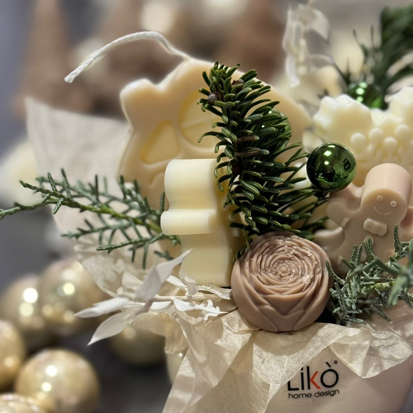 Decorative arrangement with candles, flowers, and greenery on a white surface with 'Liko Home Design' branding.