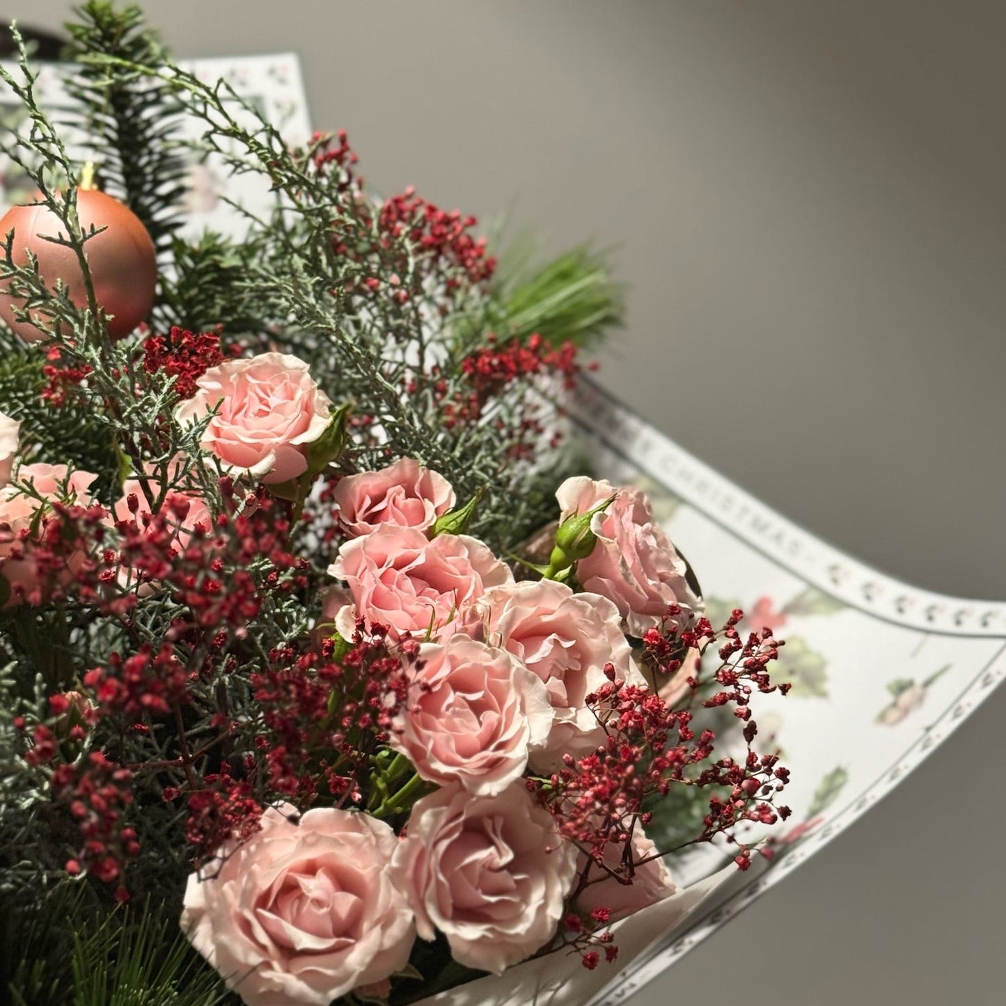 Bouquet of pink flowers with greenery on a white surface