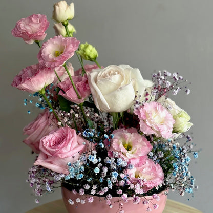 A floral arrangement featuring pink O'Hara roses, lisianthus, and rainbow gypsophila in a pink ceramic vase.