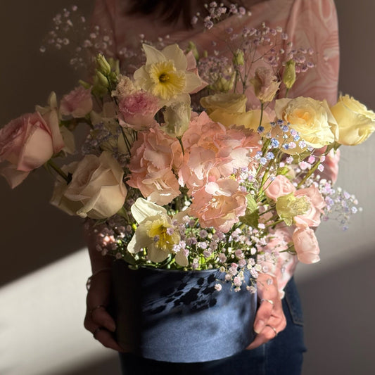 Person holding a bouquet of flowers against a neutral background
