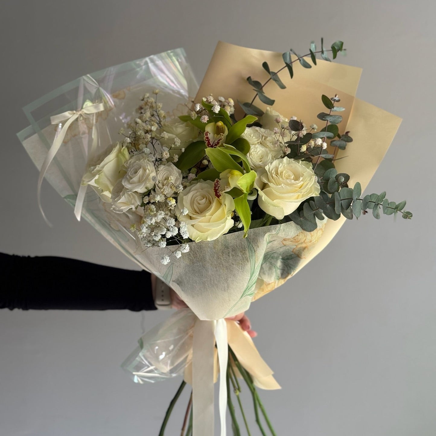 Bouquet of white roses held by a person against a blurred background
