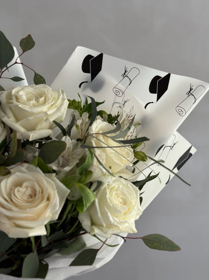 Graduation bouquet with white flowers on grey background 