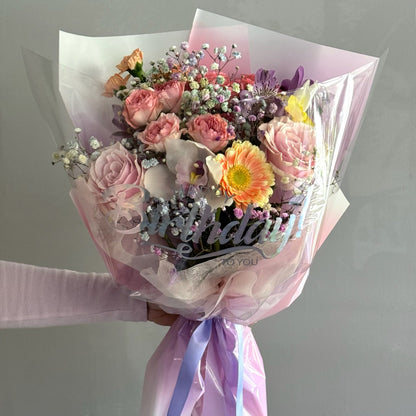 Colorful bouquet held on grey background with happy birthday wrapping