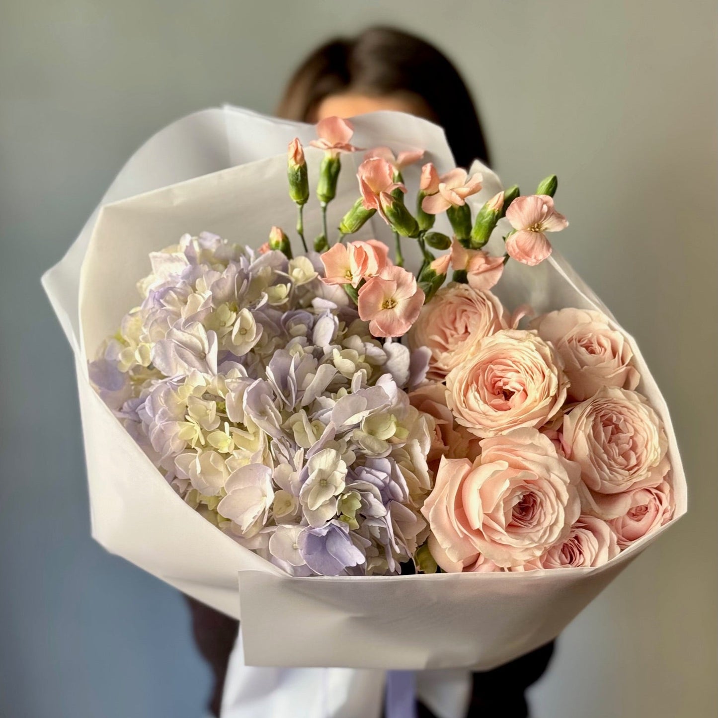 Bouquet of flowers held by a person with a blurred background
