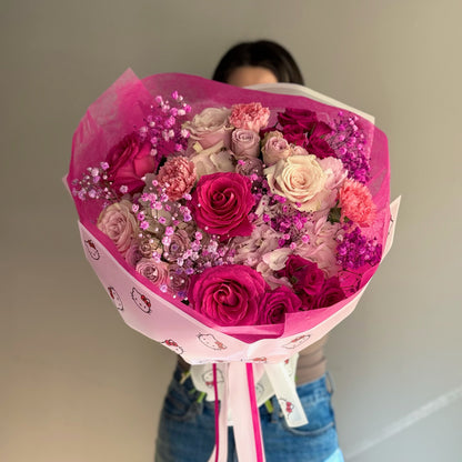Person holding pink bouquet on grey background 