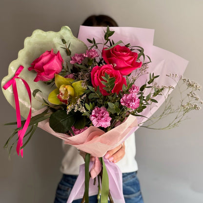 Person holding a bouquet of flowers with a plain background