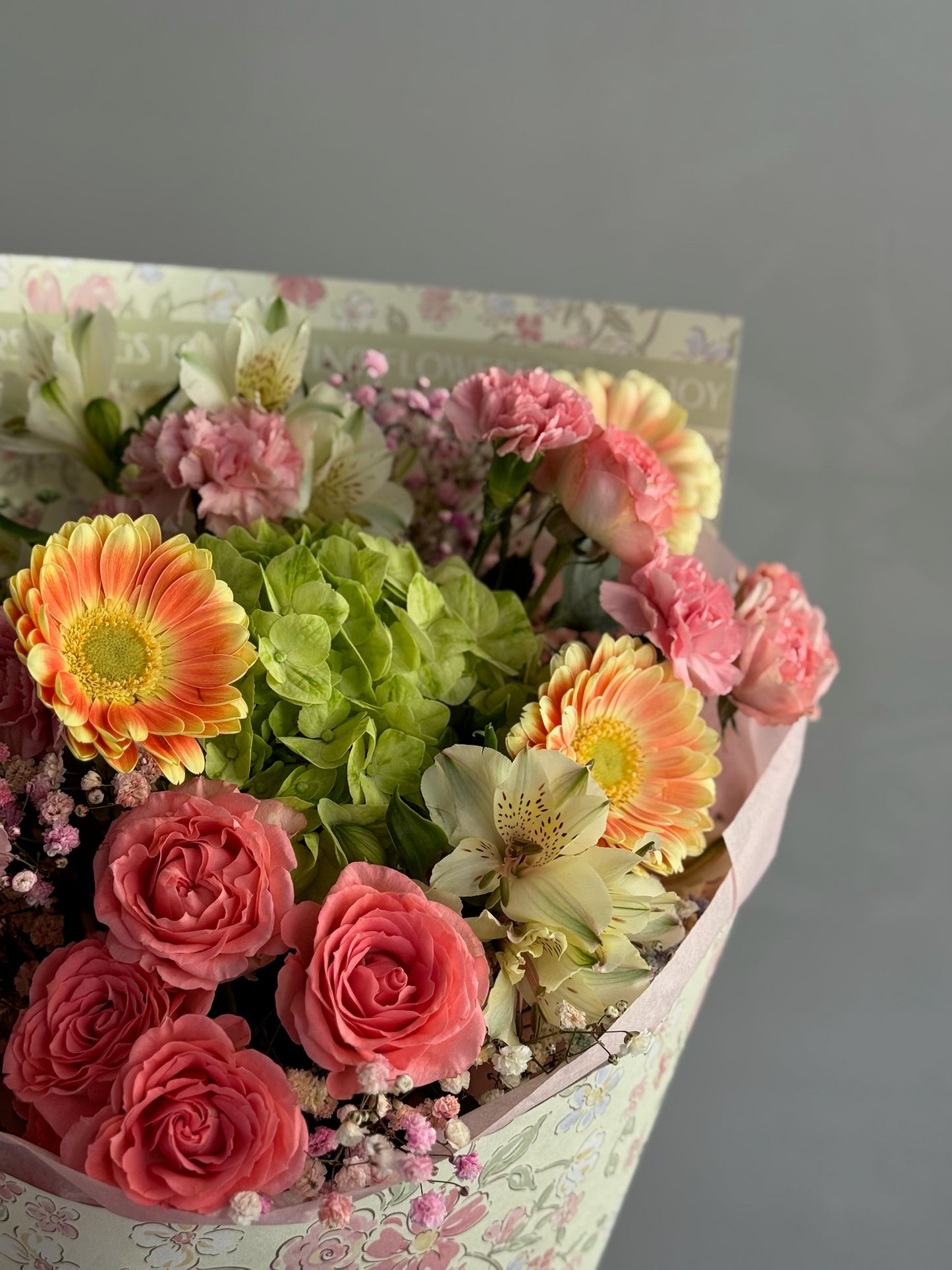 Colorful flowers with wrapping paper on grey background 