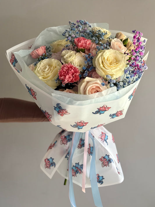 Bouquet of flowers held by a person against a plain background