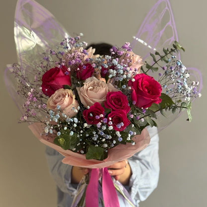 Big butterfly bouquet with ink flowers held by person on grey background 