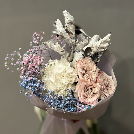 A bouquet of garden roses, hydrangea, and gypsophila with a gray and purple color scheme, arranged in a vase.