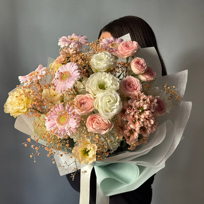 Person holdin large bouquet with white and pink flowers