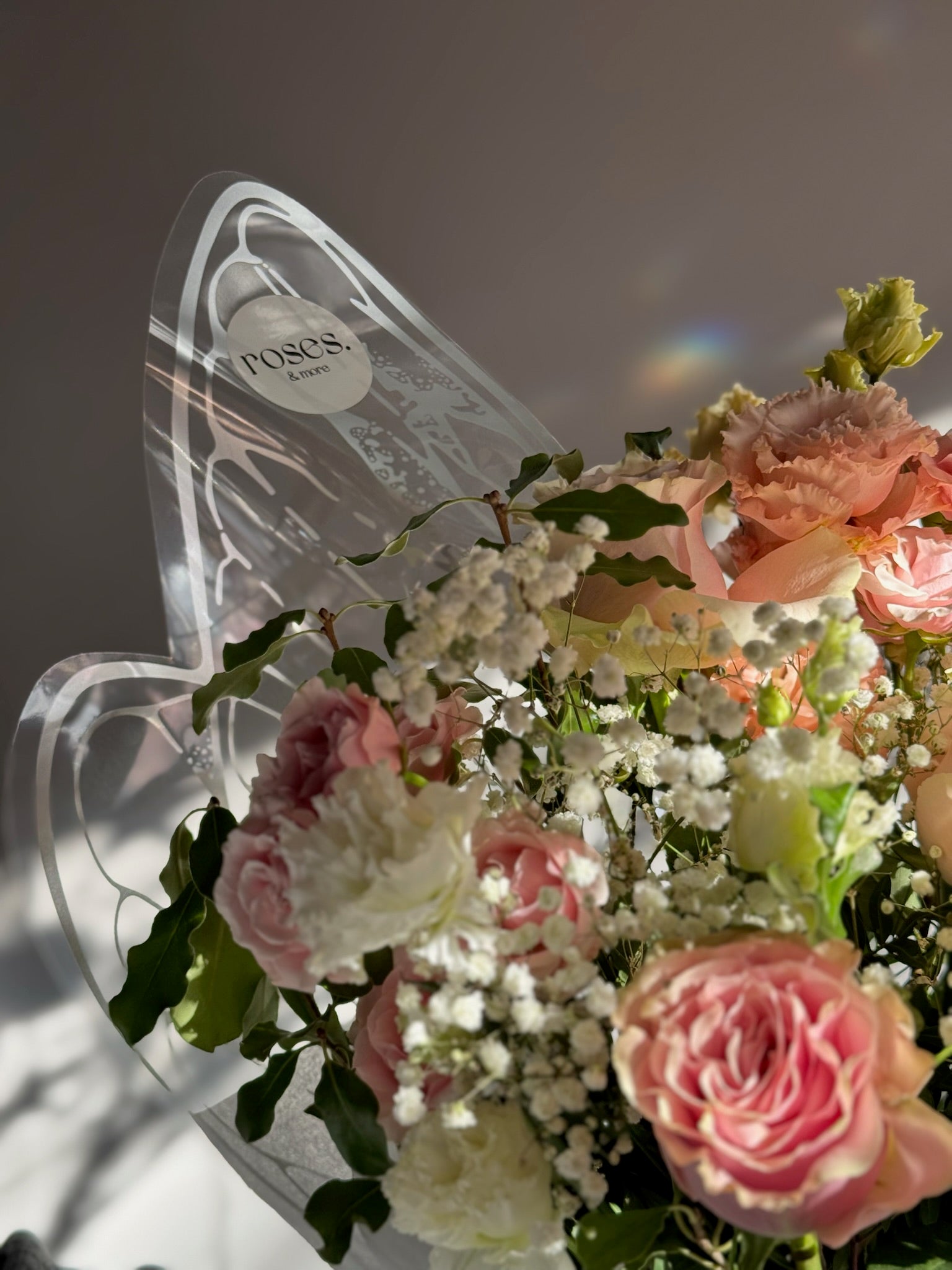 Bouquet of pink and white flowers with a decorative butterfly-shaped holder.