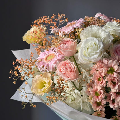 Bouquet of flowers with white, pink, and yellow colors on a dark background