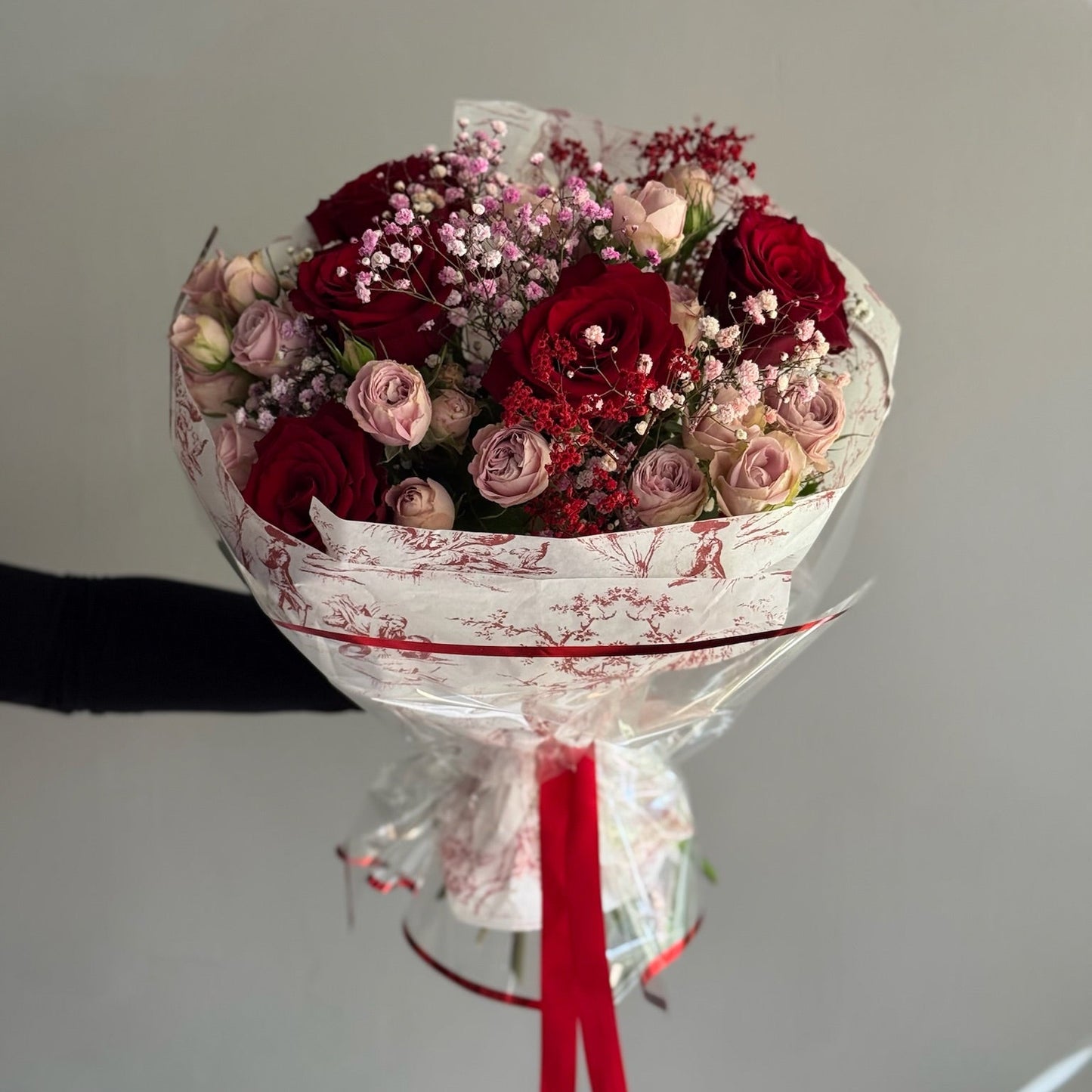 Bouquet of red and pink roses with a grey background