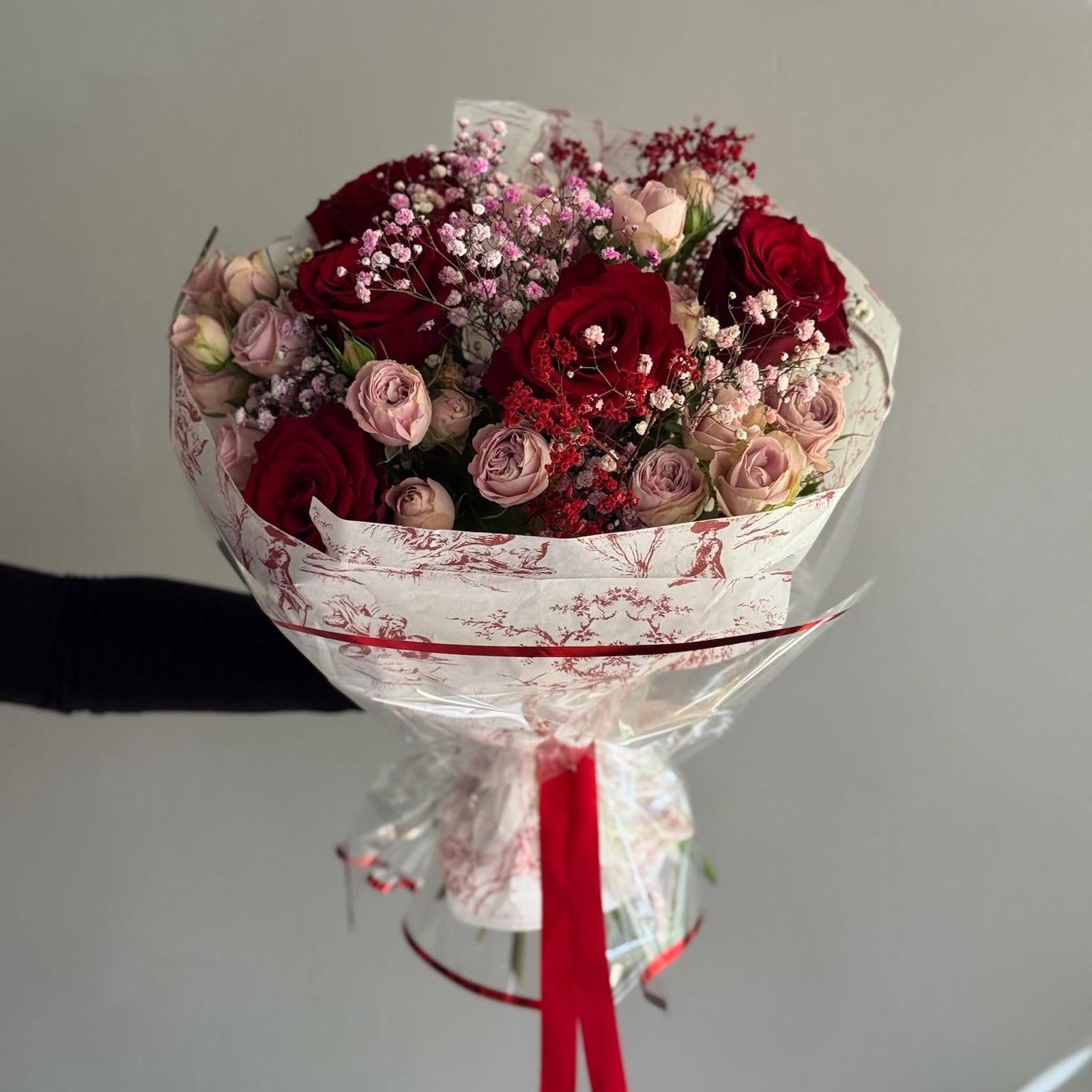 Bouquet of red and pink roses with a grey background