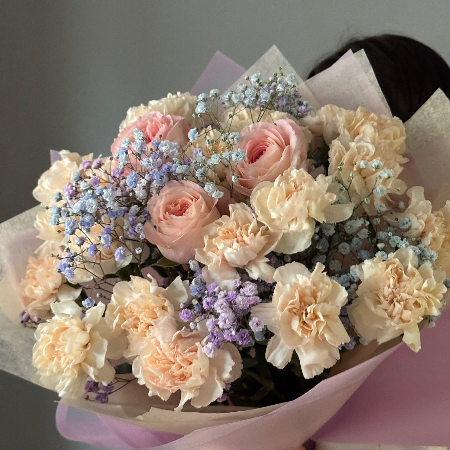 Bouquet of flowers with pink and beige tones on a plain background