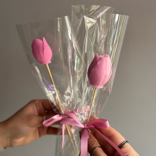 Little candle tulip in bouquet held on grey background 