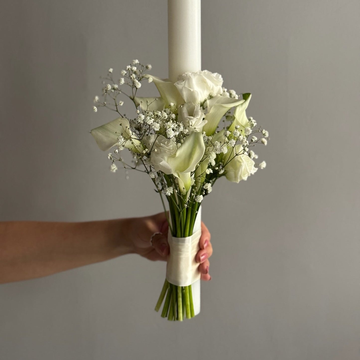 White wedding candle against grey background 