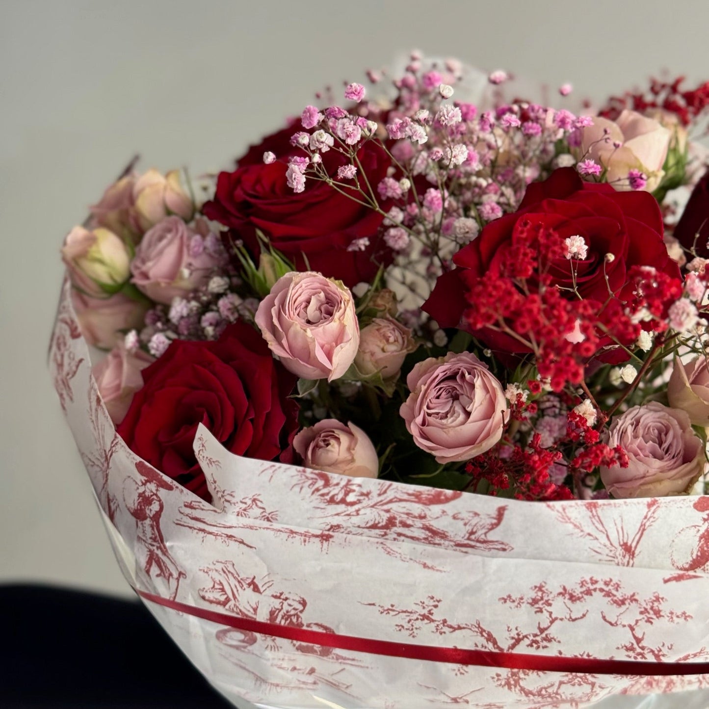 Red bouquet of red and pink roses with a blue background