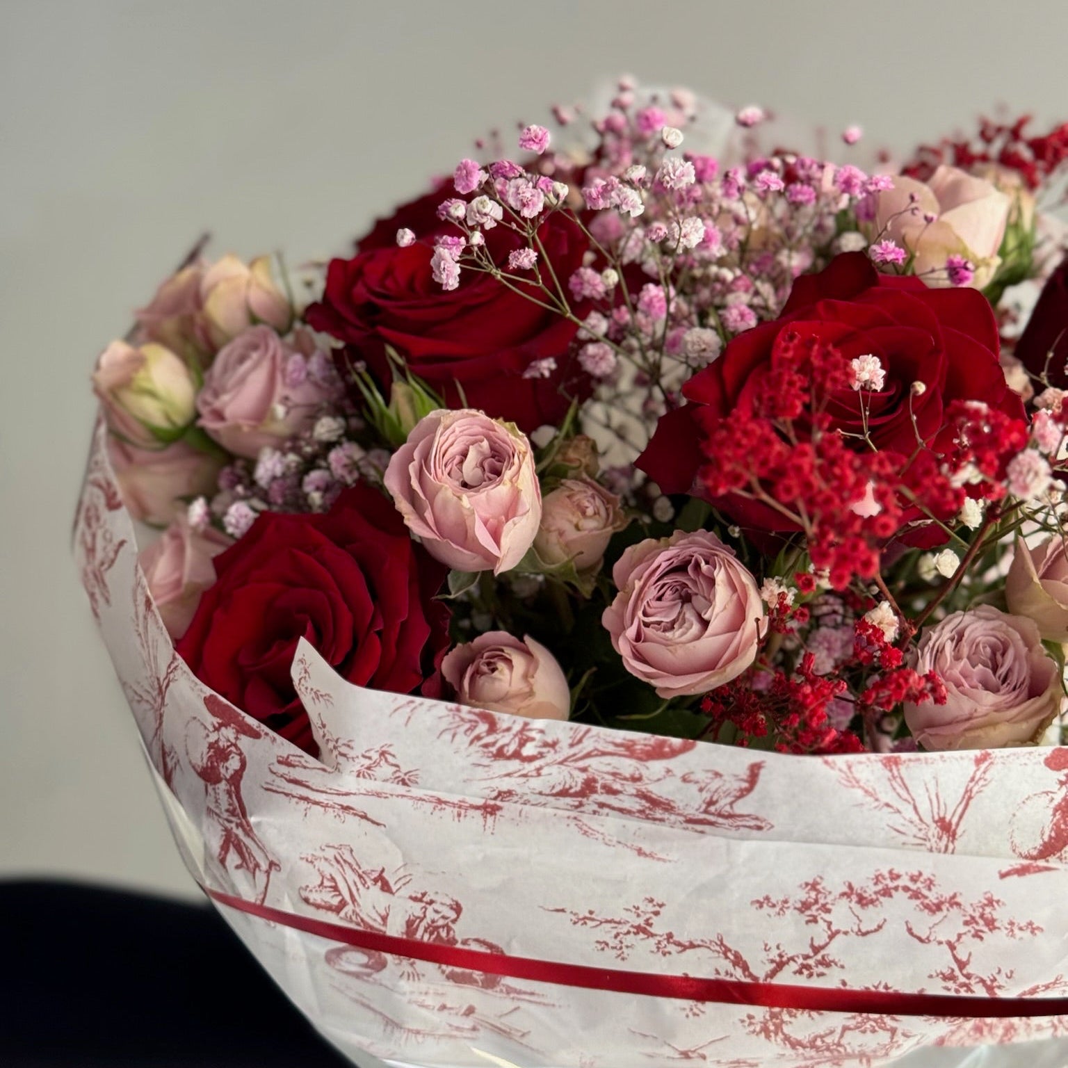 Red bouquet of red and pink roses with a blue background