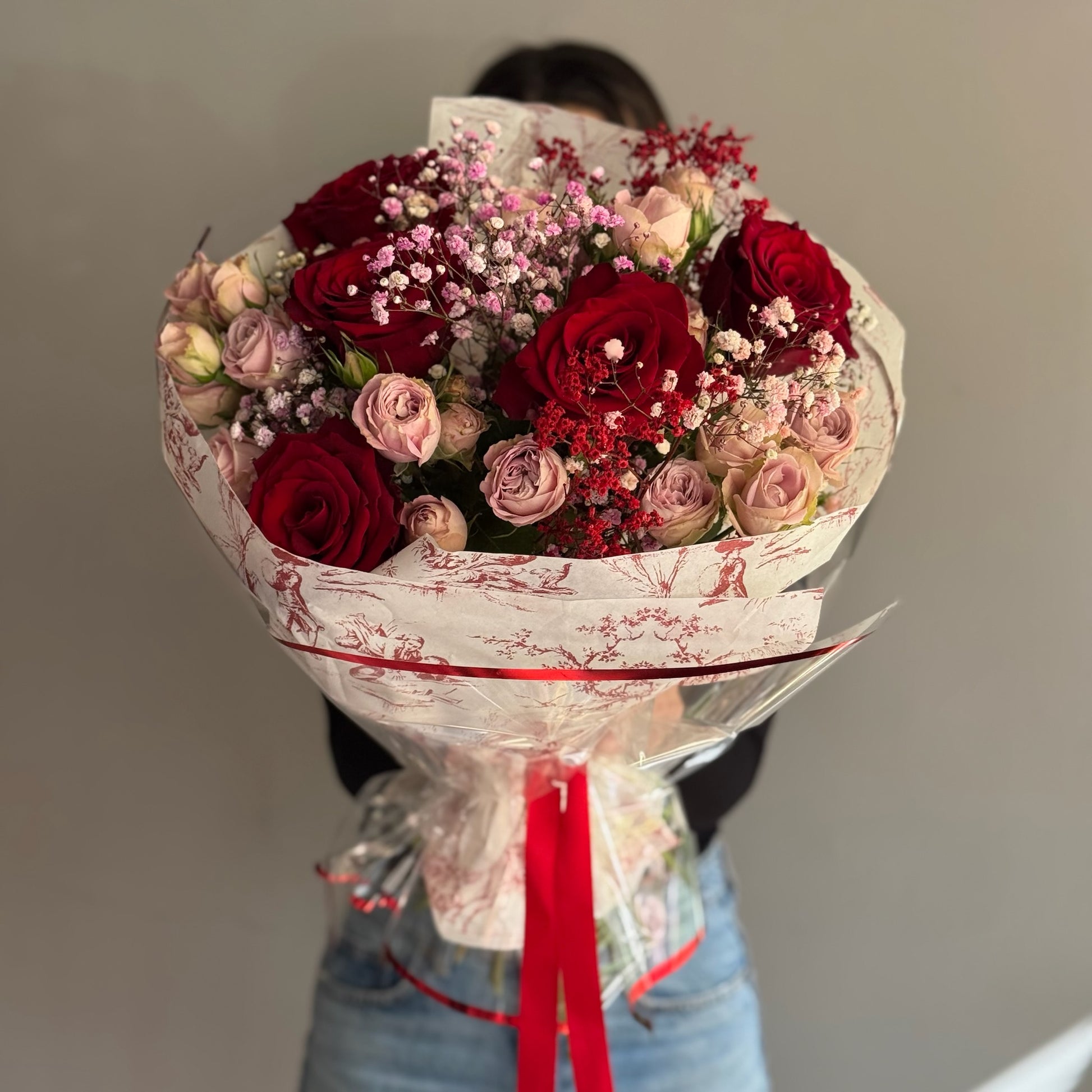 Bouquet of red and pink roses with a blue background