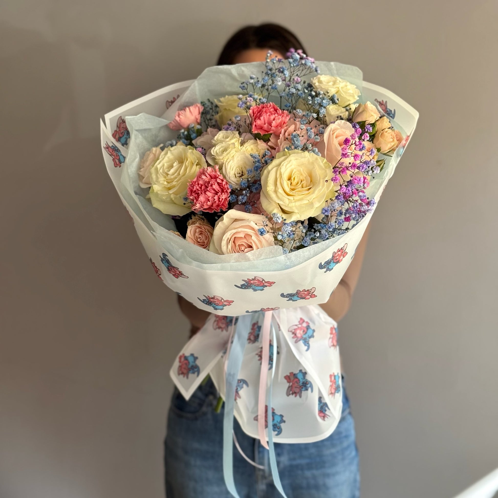 Bouquet of flowers white held by a person against a plain background