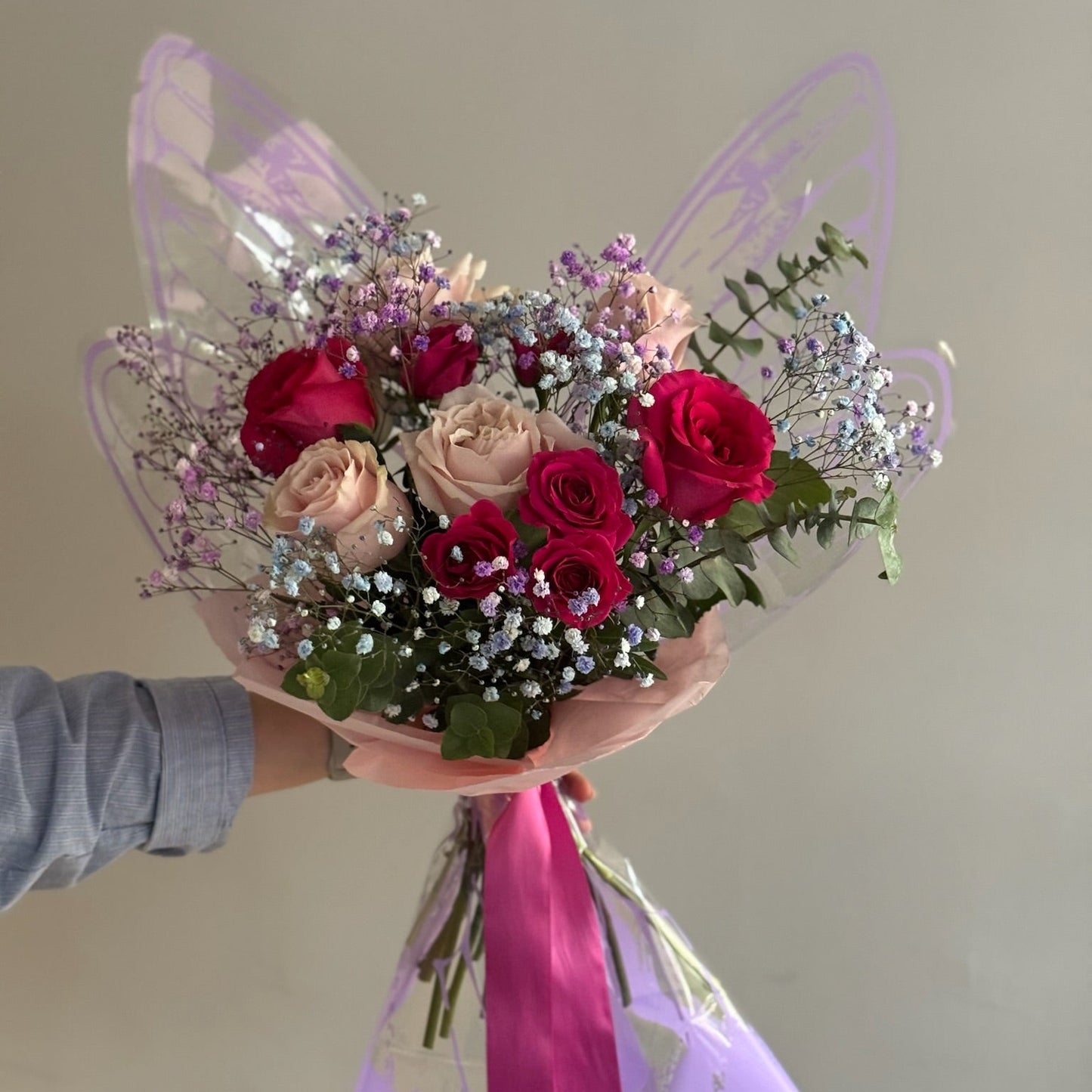 Bouquet with butterfly wrapping paper on grey background 