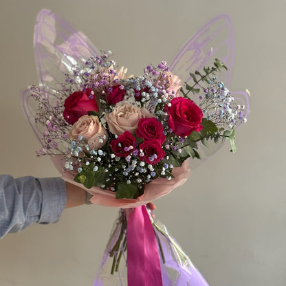 Bouquet with butterfly wrapping paper on grey background 