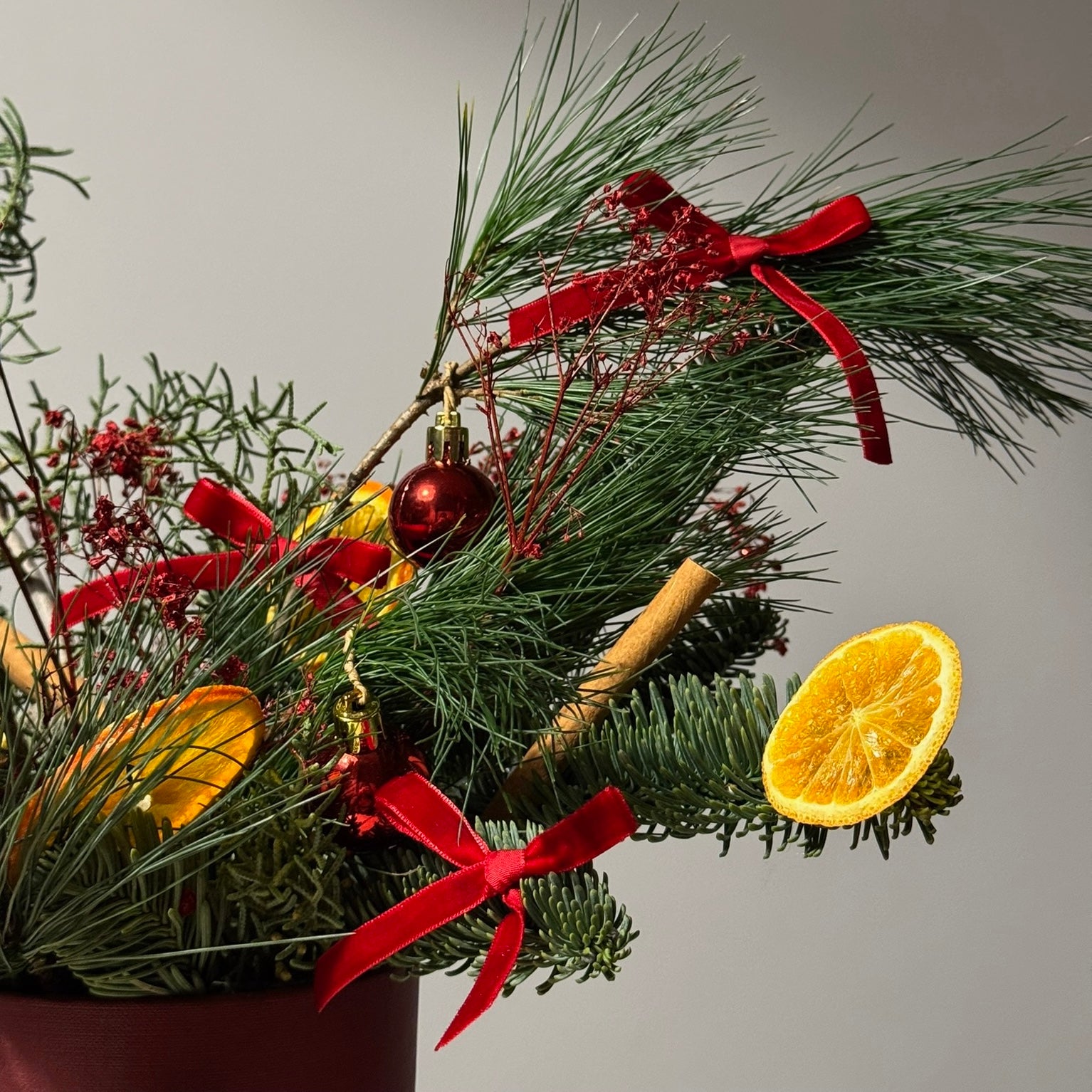 Aranjament de Crăciun cu conifere naturale, globuri decorative și fundițe