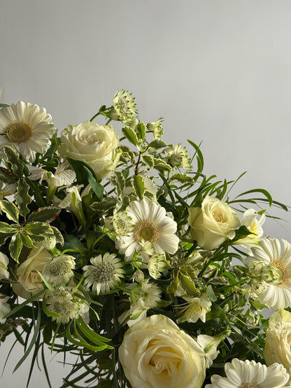 Bouquet of white and green flowers on a light gray background