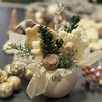 Decorative arrangement with white flowers, greenery, and a 'Liko' branded vase on a blurred background.