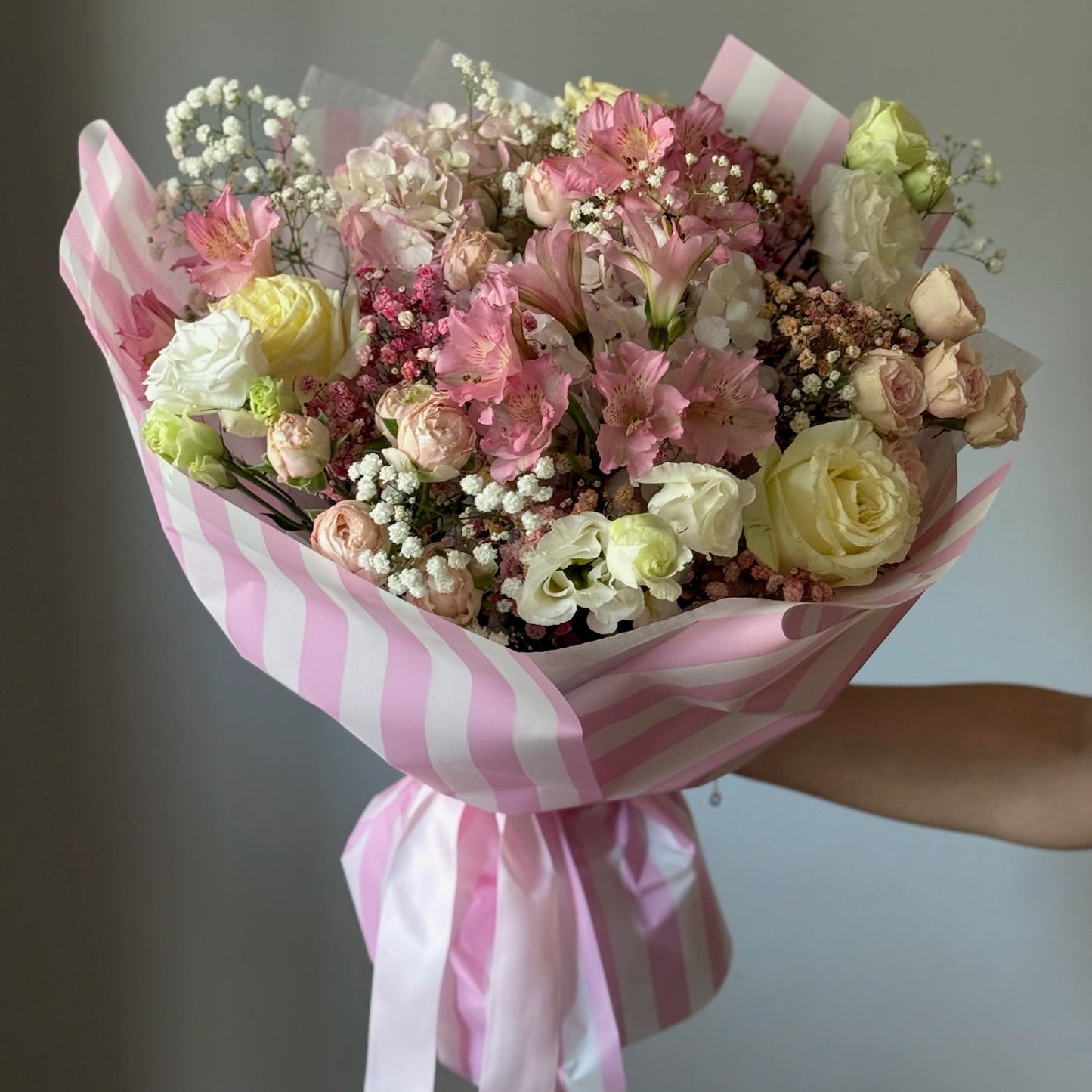 Buchet elegant cu trandafiri și hortensie în nuanțe de alb și roz, cu ambalaj roz cu dungi