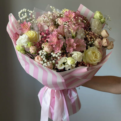 Buchet elegant cu trandafiri și hortensie în nuanțe de alb și roz, cu ambalaj roz cu dungi