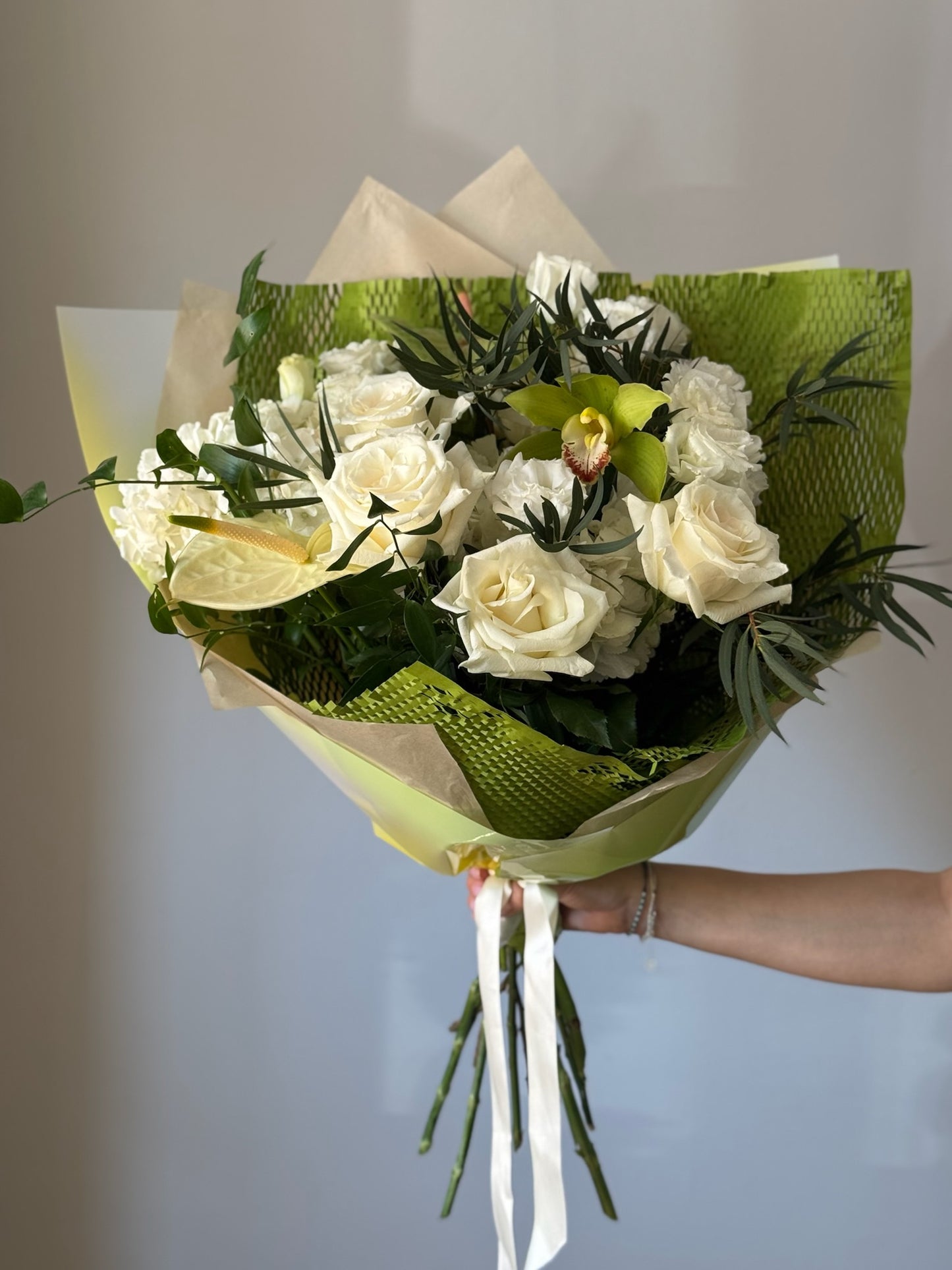 White flowers with greenery in a big bouquet on grey background 
