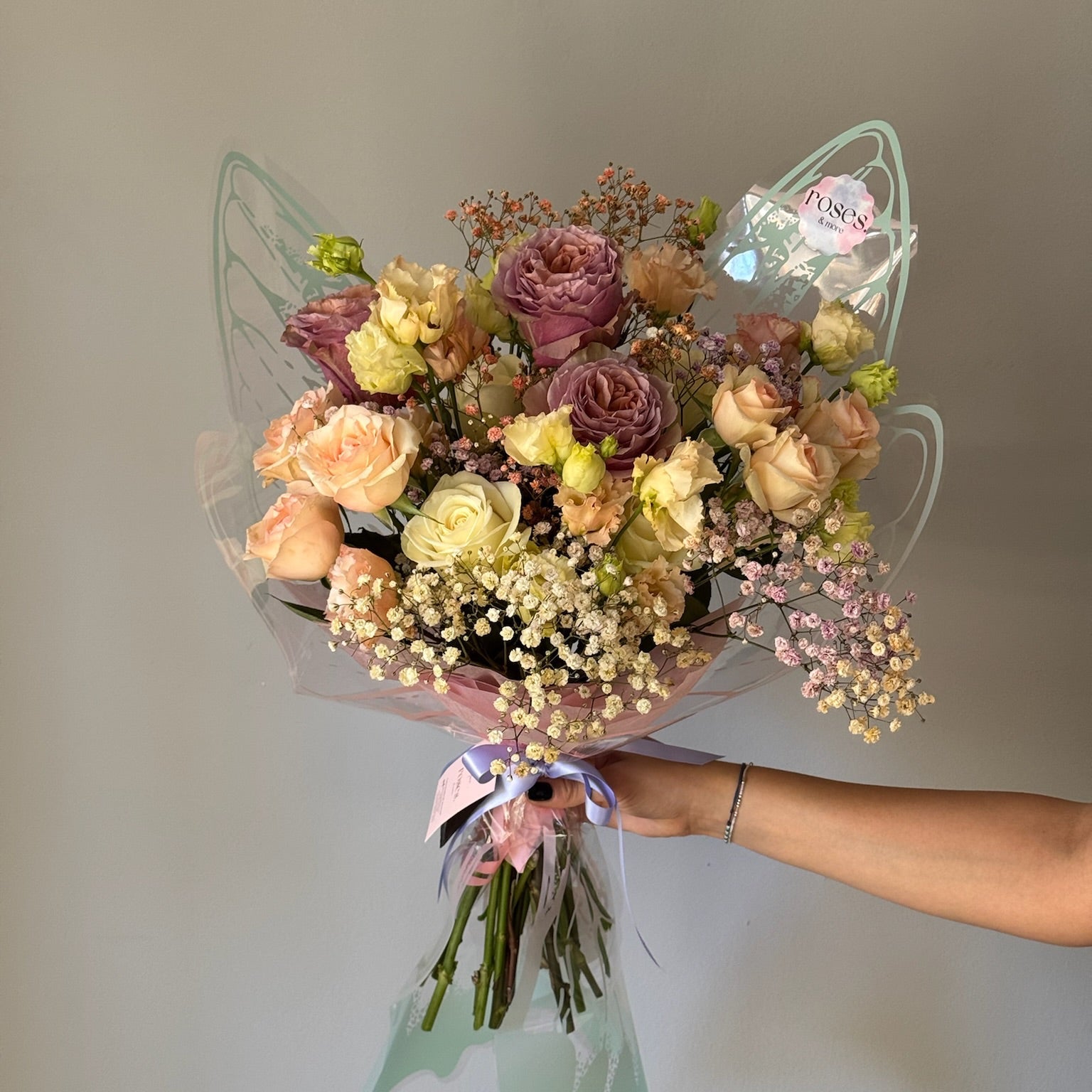 Bouquet of flowers held by a person against a neutral background