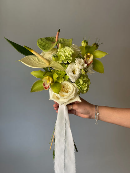 Green flowers in bouquet held on grey background 